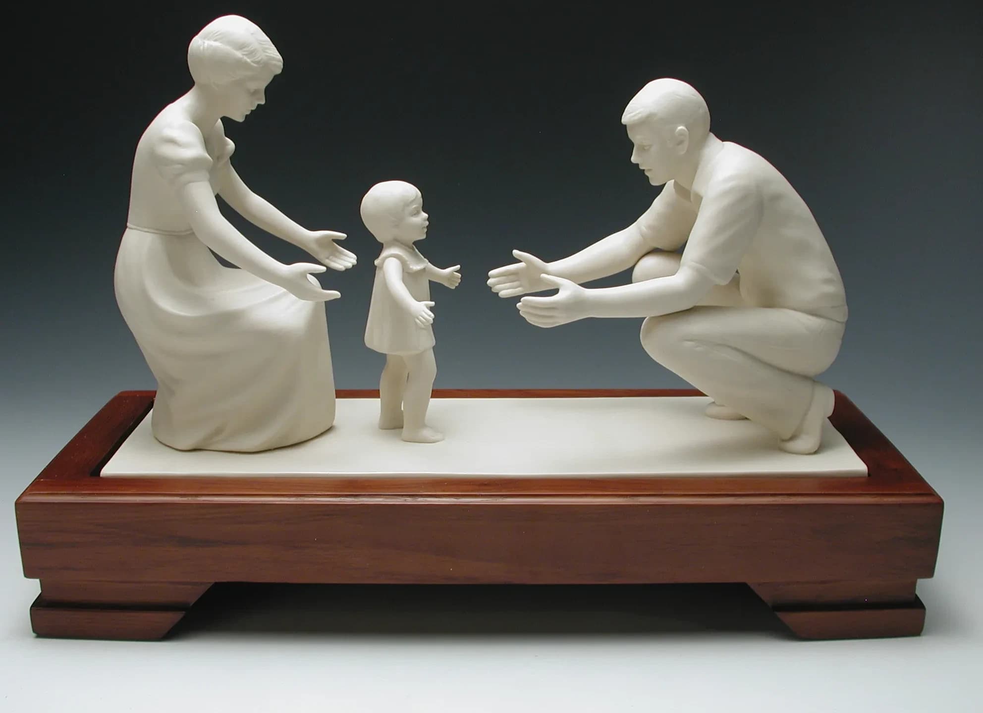 White porcelain figurine of a mother and father reaching out to a toddler taking her first steps between them, on a long timber base